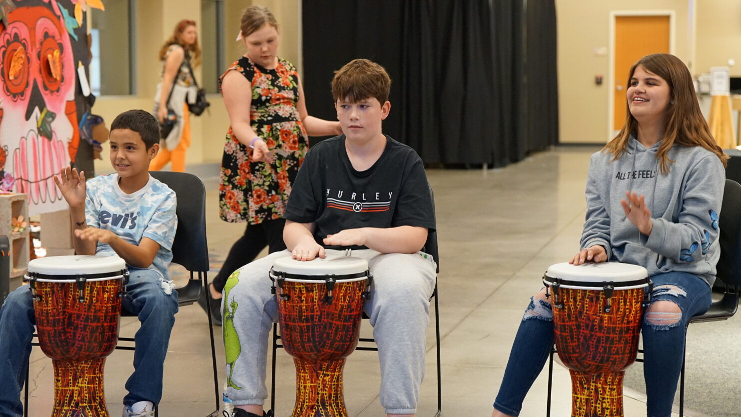 Students play the djembe drums.
